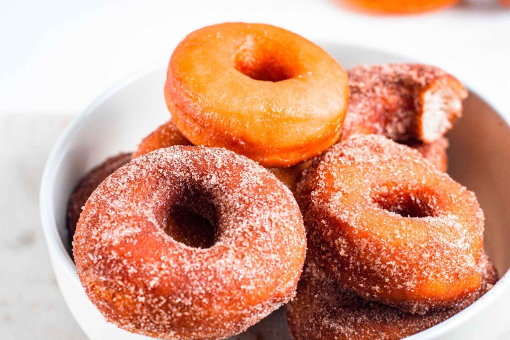 donuts in a white bowl made with this sourdough donuts recipe