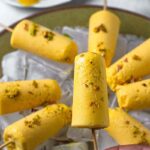 8 mango popsicle on ice garnished with pistachios