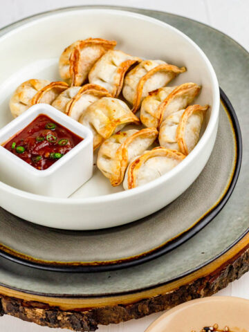 10 frozen potstickers made in air fryer served in a plate with sauces