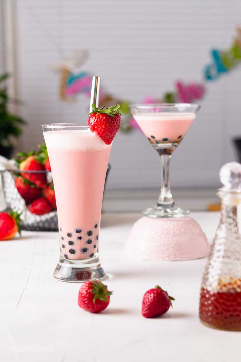 two glasses with strawberry milk tea and fresh strawberries