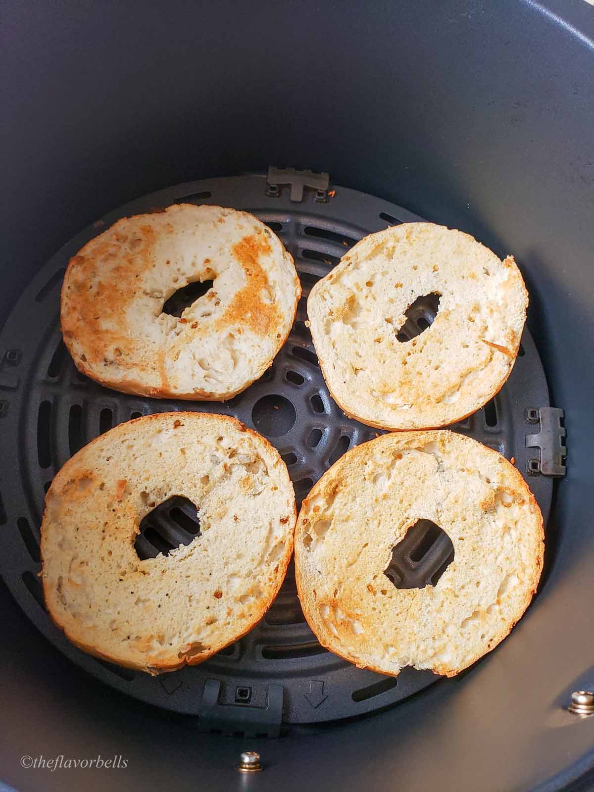 bagel placed cut side up in an air fryer basket