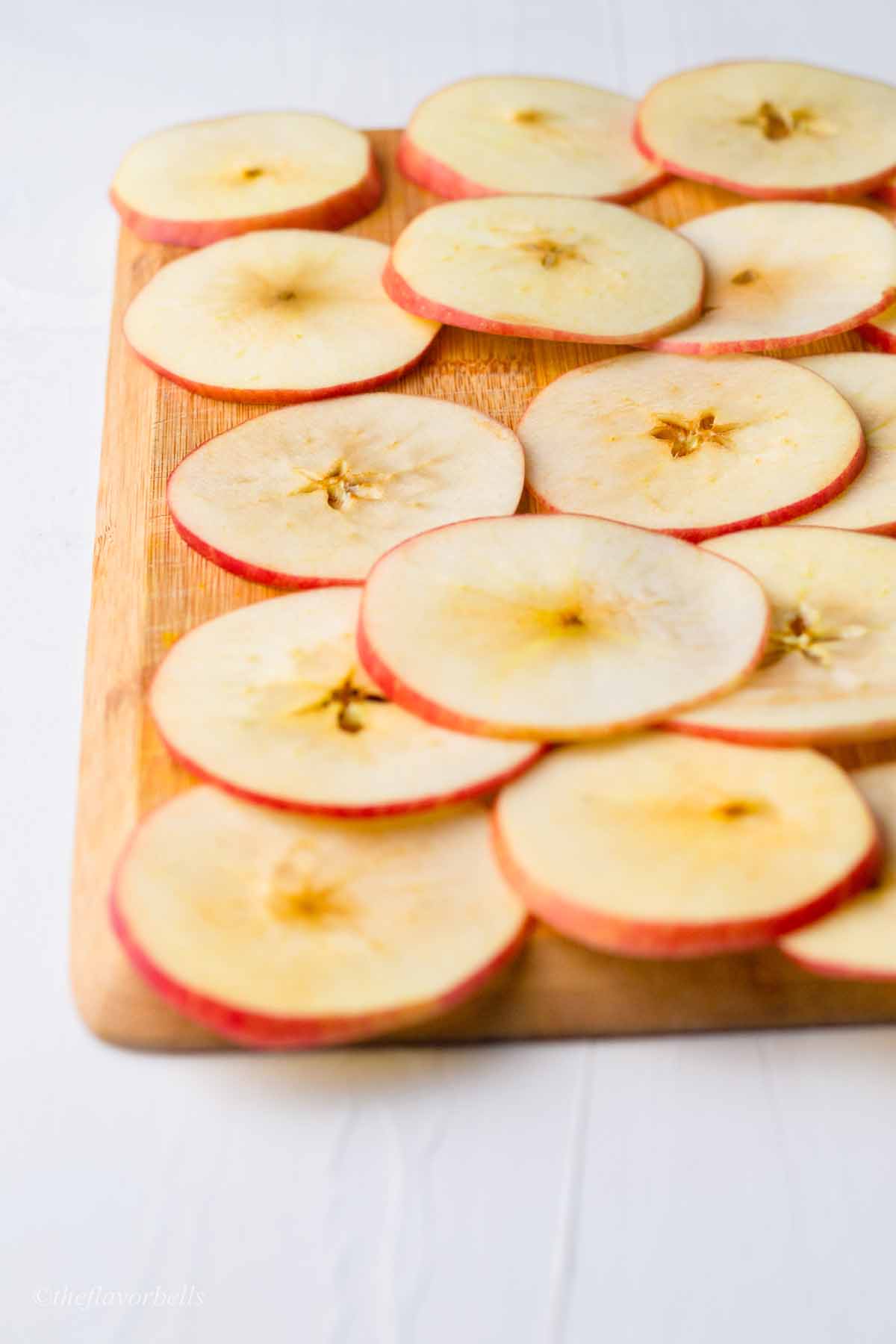 thin slices of apples on a wooden board