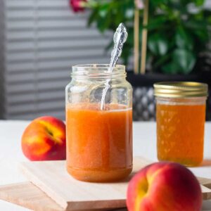 Peach syrup filled in jars that is going to be used for making tea and drinks