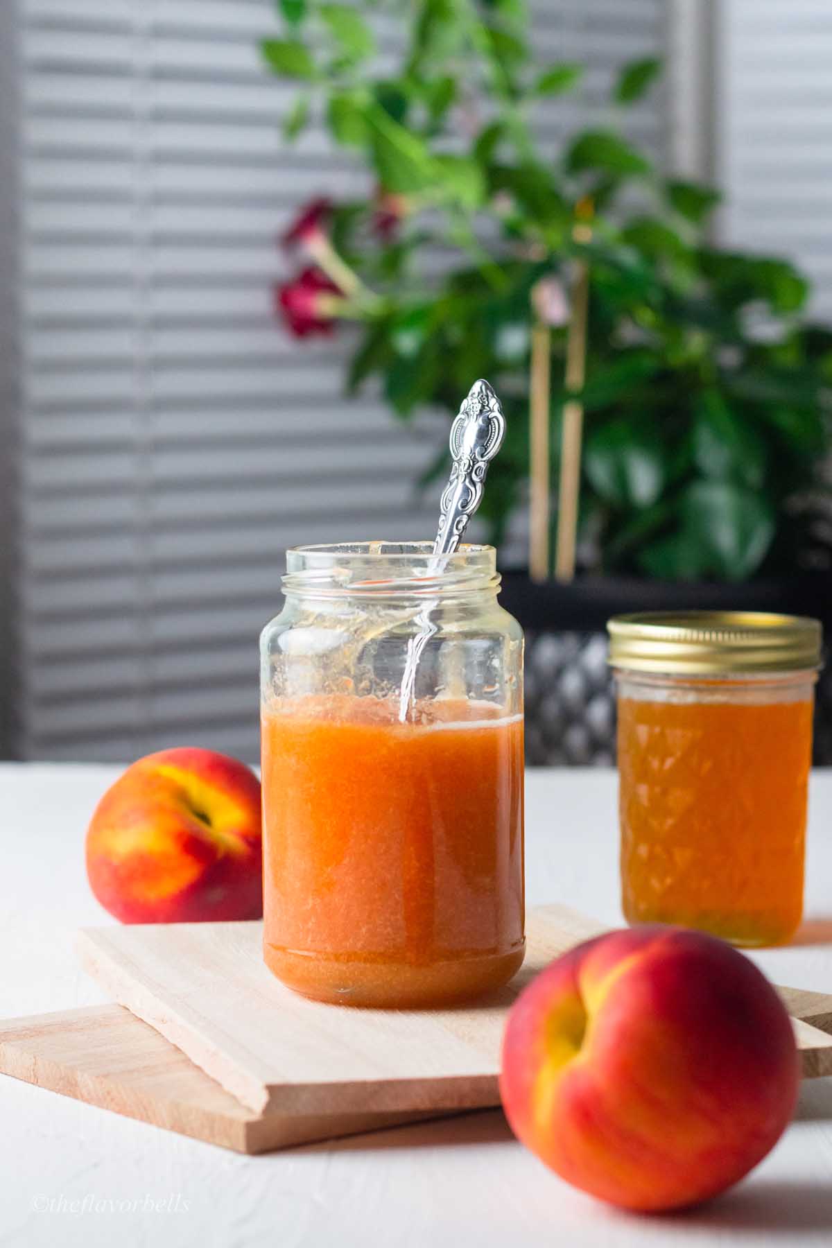peach syrup in glass jars with a spoon