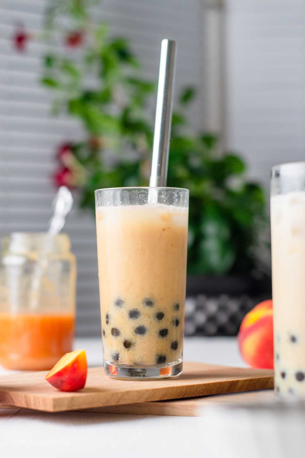 peach boba tea served with black boba pearls