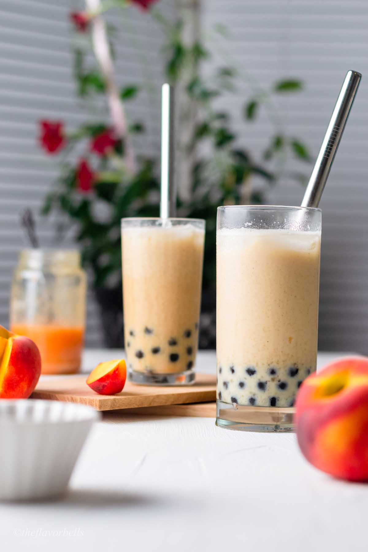 two glasses filled with peach milk tea