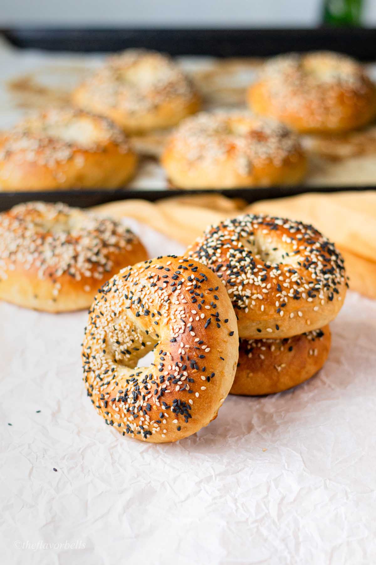 three sesame seed bagels leaning over one another
