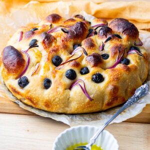 sourdough discard focaccia topped with red onions and olives.