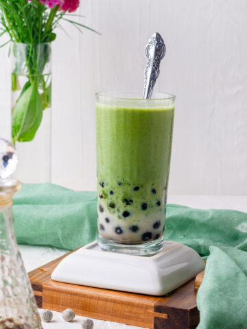 a glass of matcha boba with black tapioca pearls