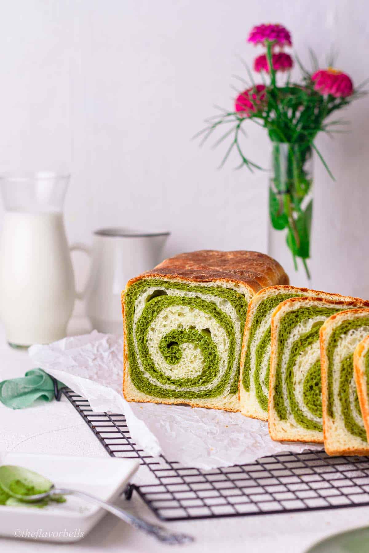 half a bread loaf and a few cut slices of green and white milk bread