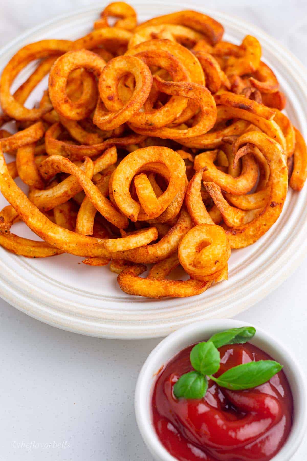 a closeup look at the crispy and golden texture of frozen curly fries cooked in an sir fryer.