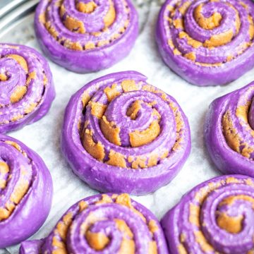 ube cinnamon rolls proofing in a pan before being baked