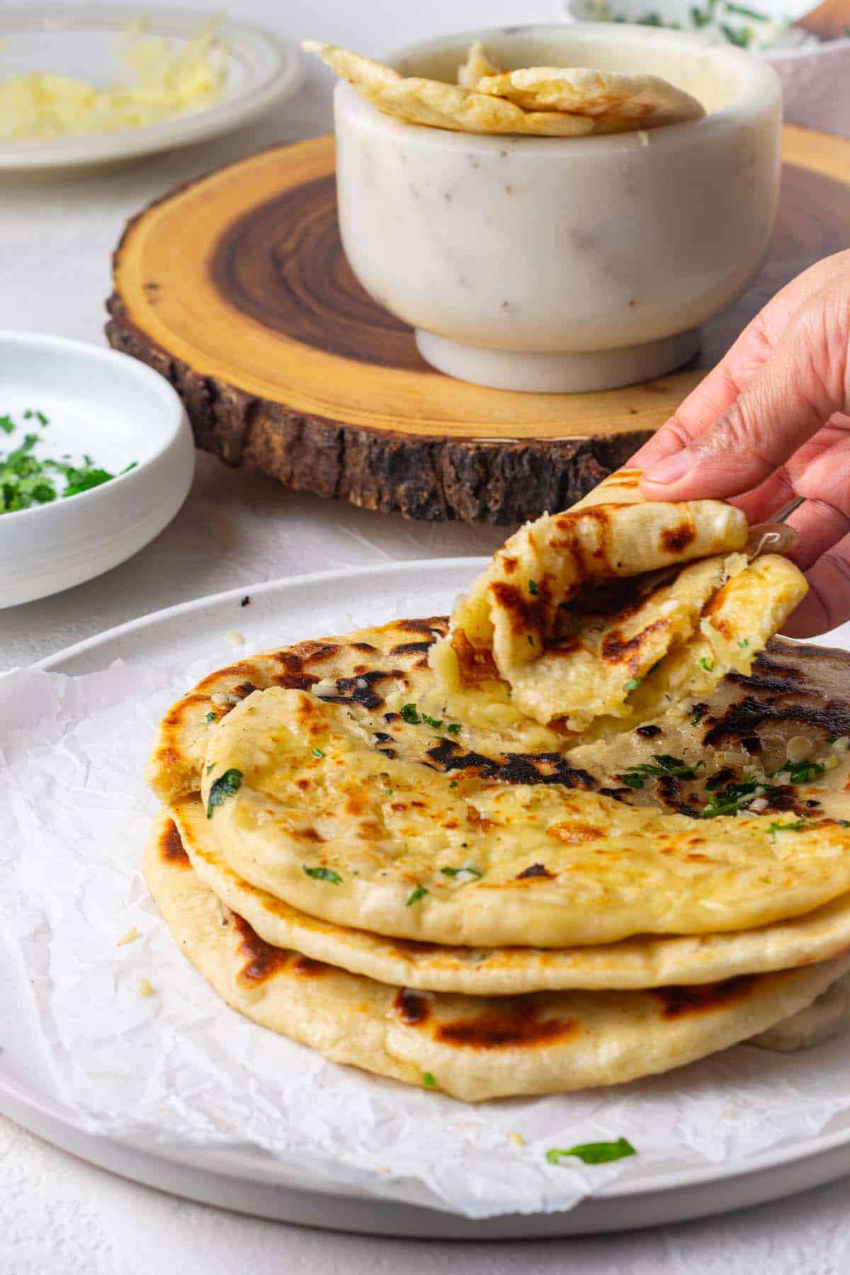 folding cheese naan to show how soft and tender they are