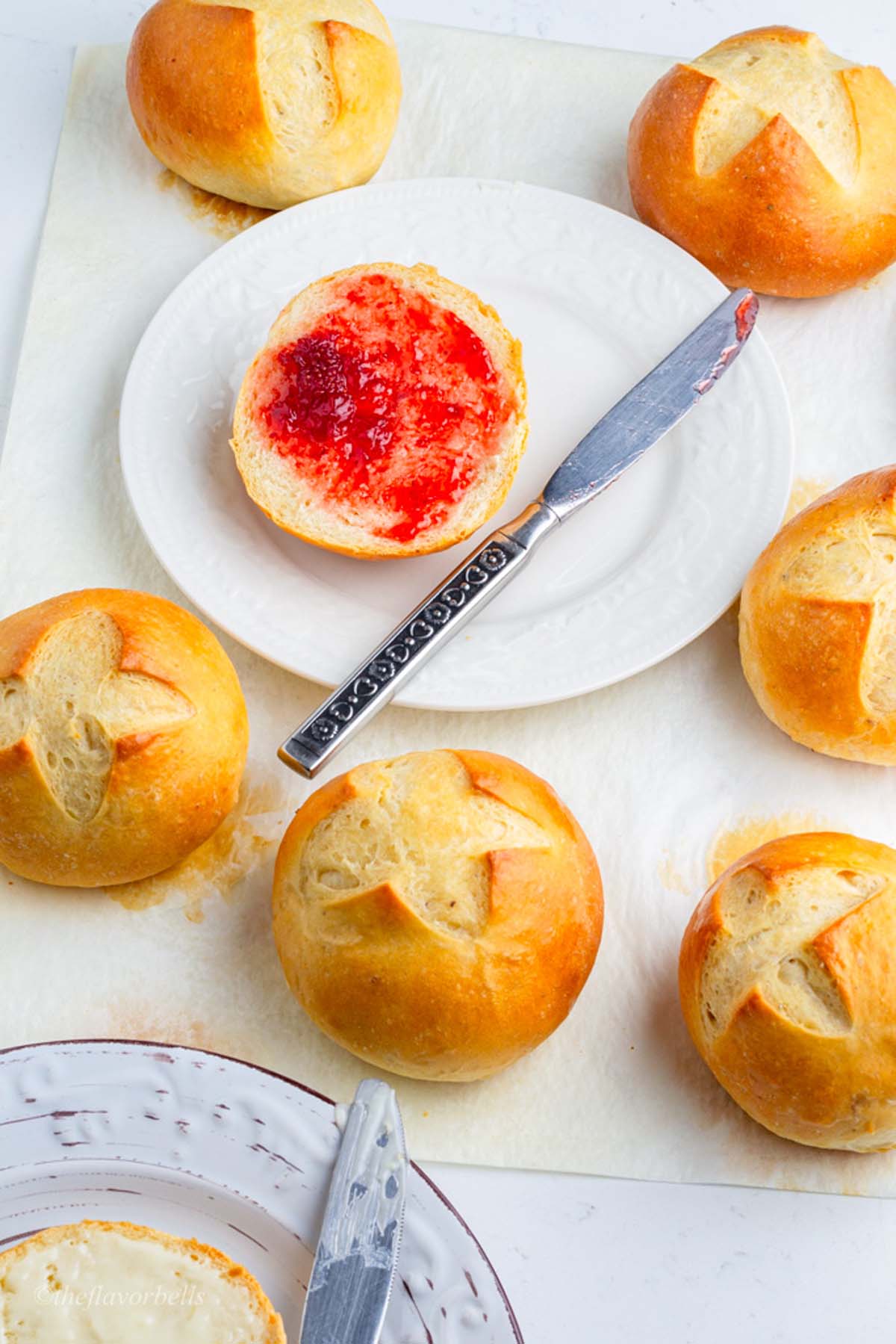 one bun sliced and smeared with strawberry jam and 6 more Danish buns around it