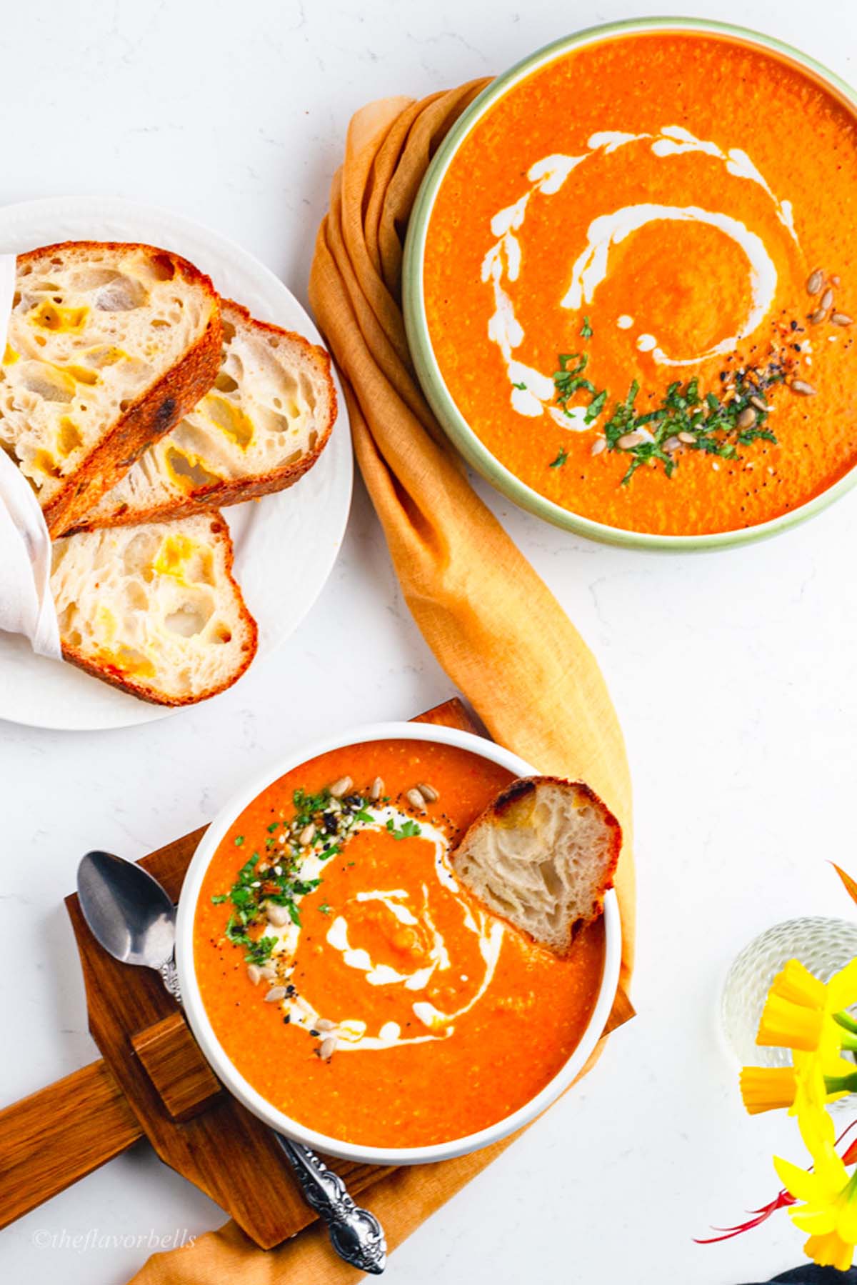 overhead shot of the soup served in two bowls and sourdough bread in the side plate