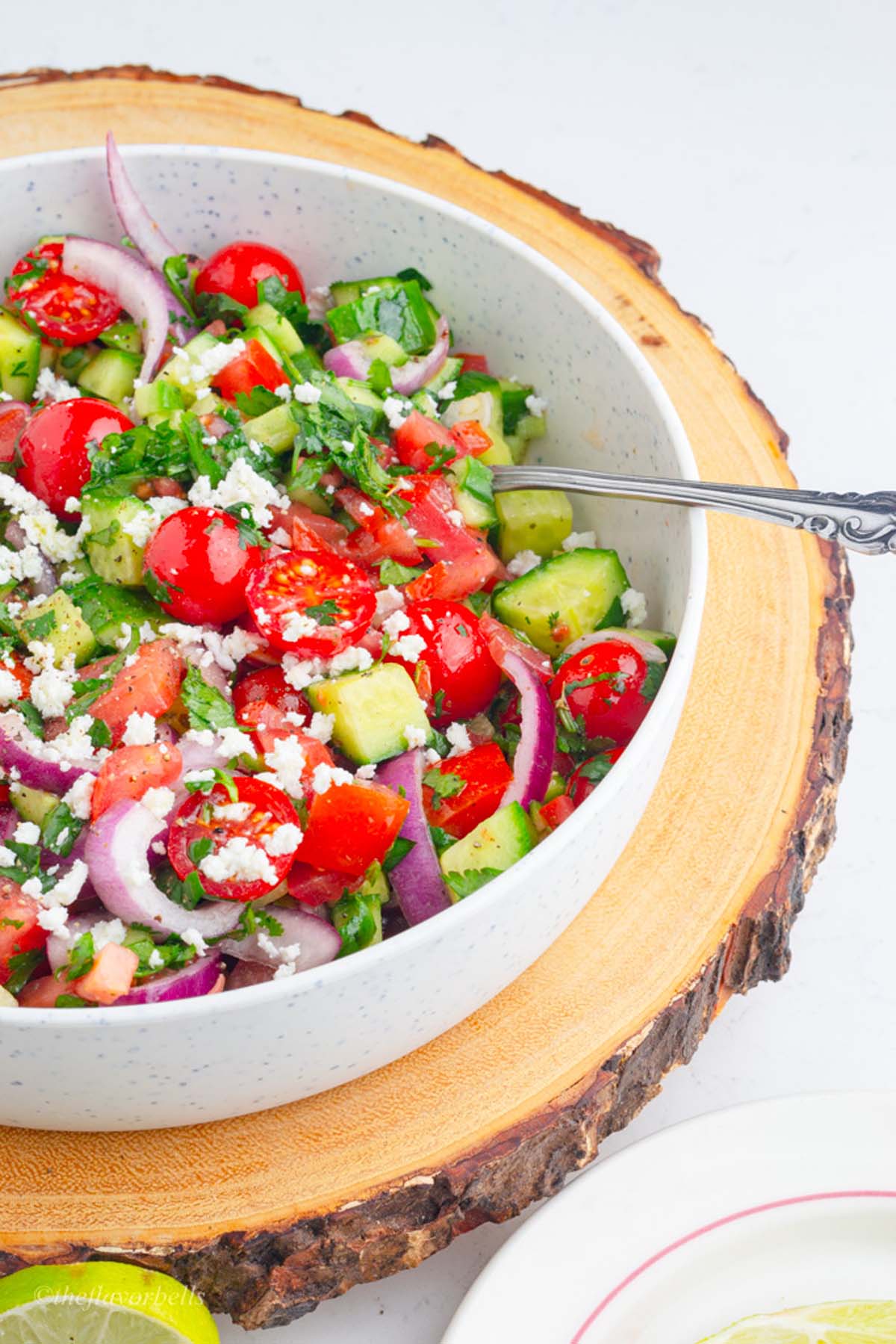 a bowl filled with refreshing and colorful mediterranean cucumber and tomato salad