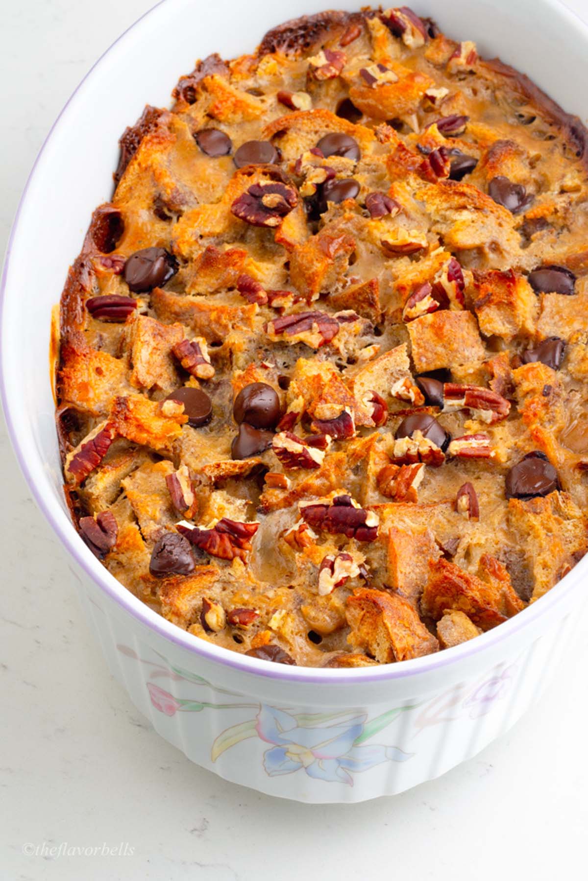 a casserole of sourdough pudding topped with chopped pecan and chocolate chips with caramelized custard on the edges. So good!