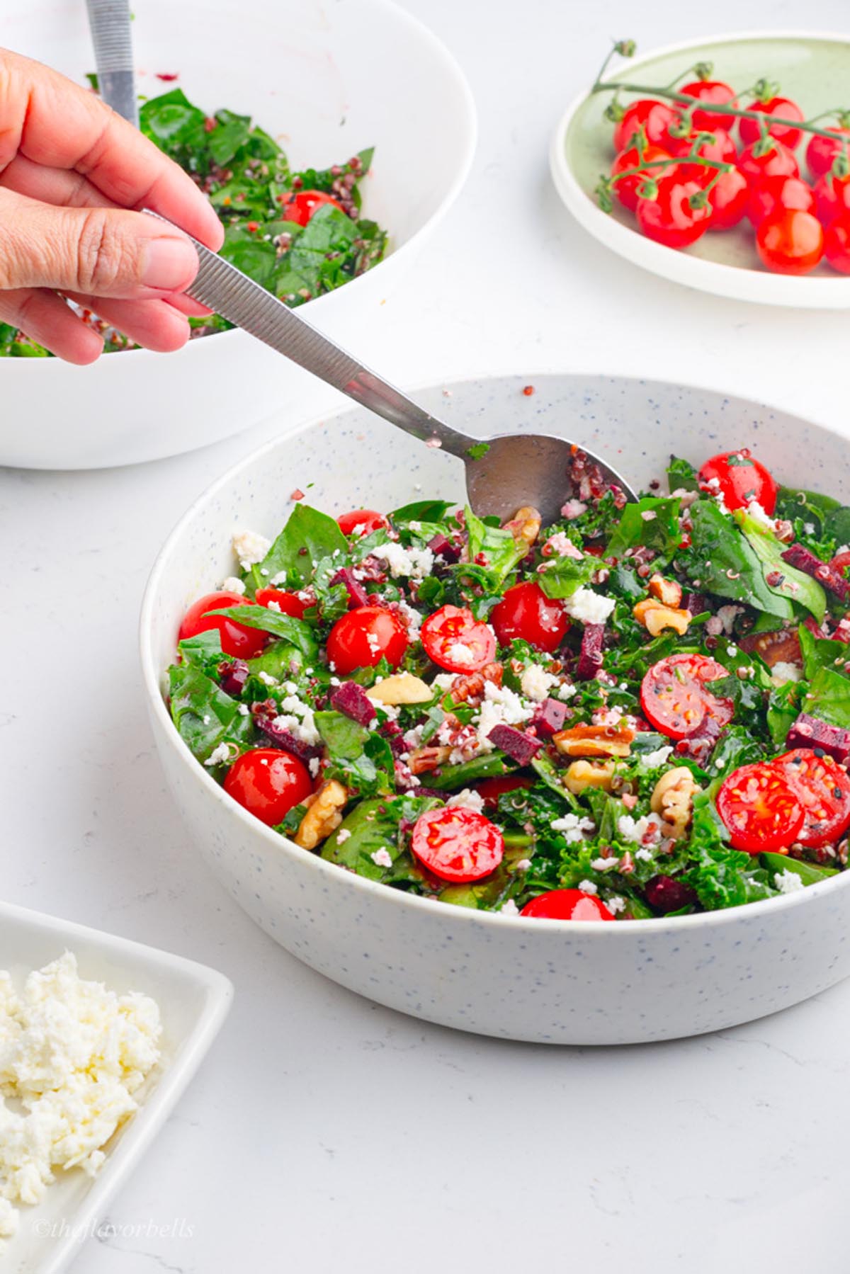 a scene of serving the salad with a spoon from the salad bowl and another bowl in the background