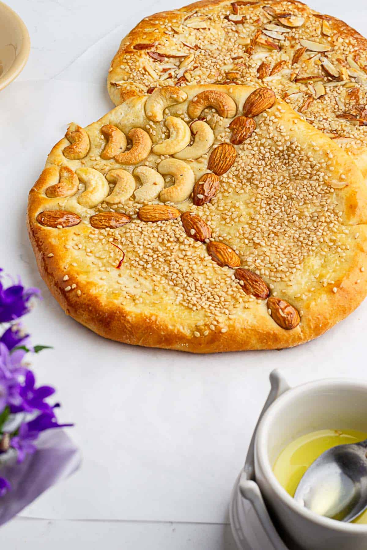two freshly made sweet and nut filled sheermal with saffron syrup vessel in foregraound
