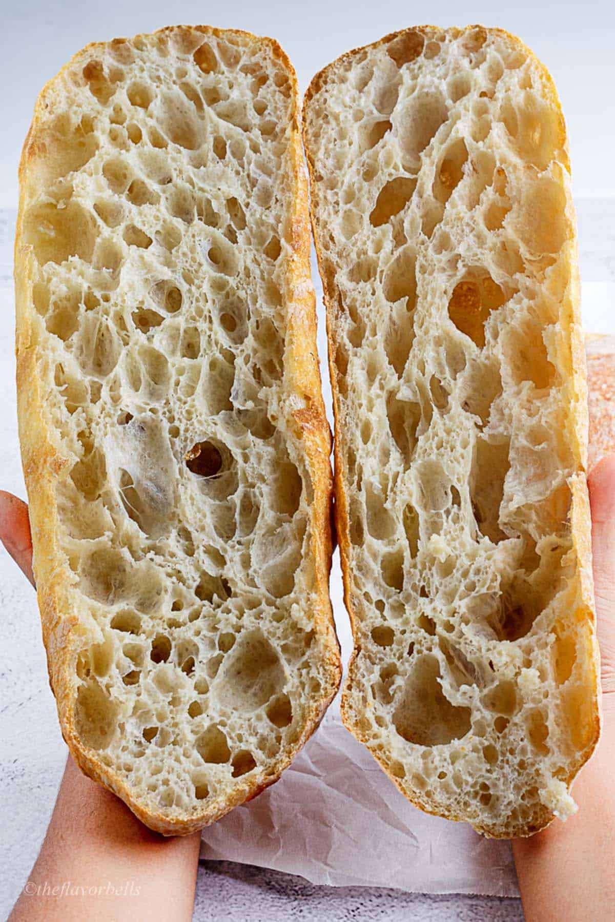 sliced ciabatta bread held in hands to give a closer look of the crumbs