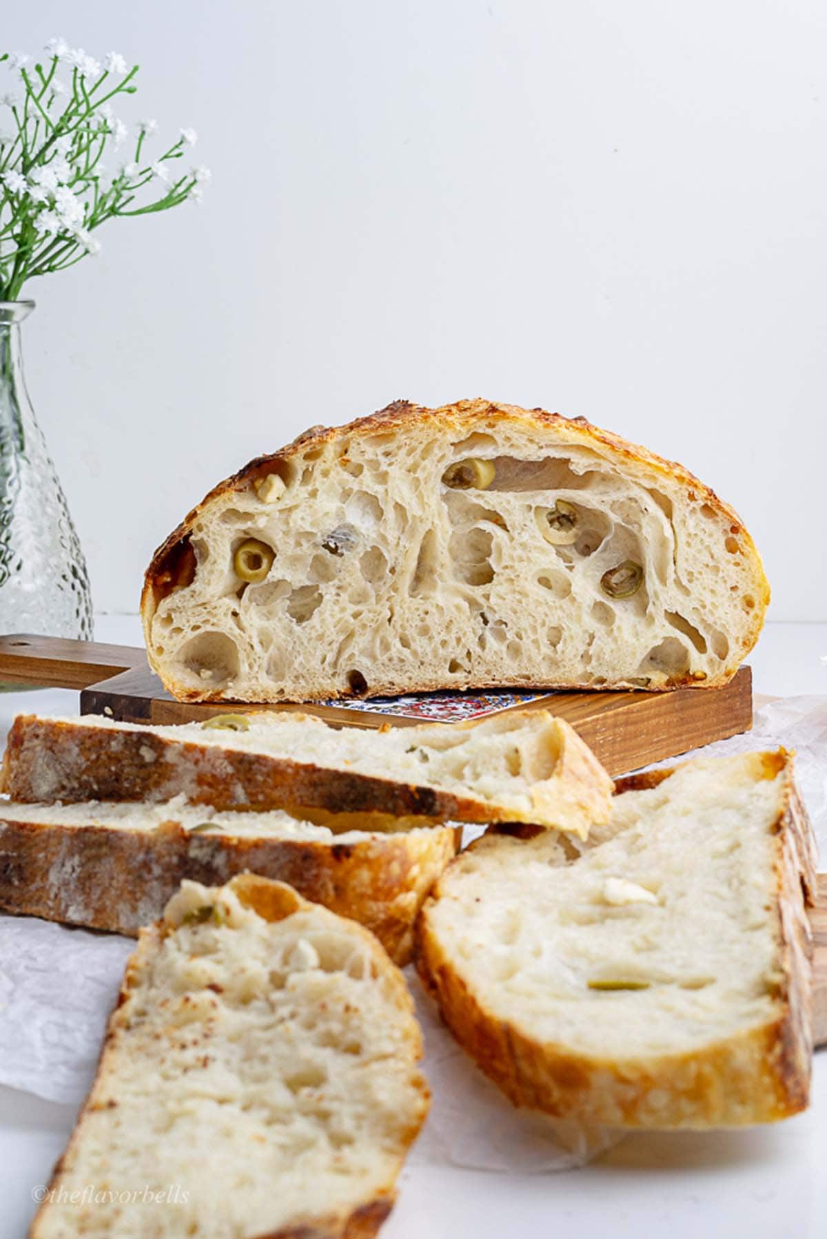 a loaf of feta sourdough sliced into half to show the open crumbs