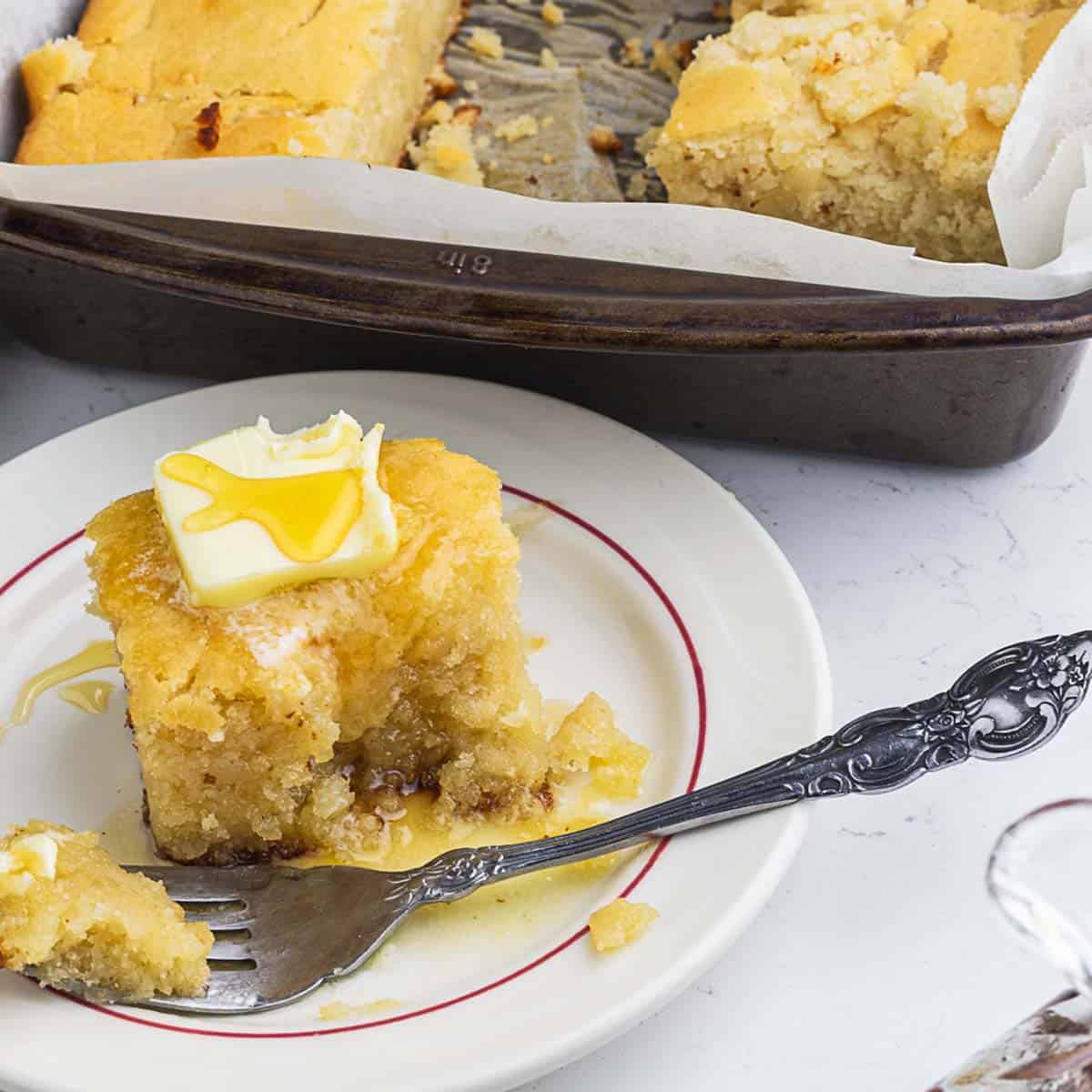 sourdough cornbread slice served in a plate topped with honey and butter
