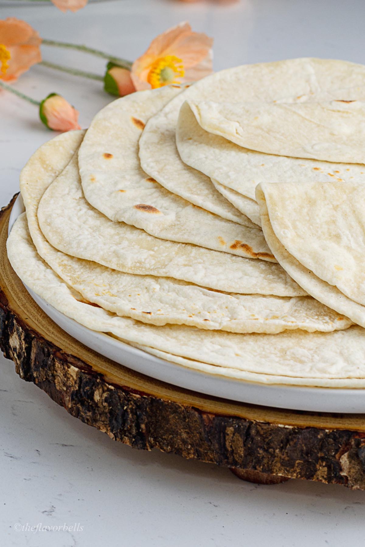 a close up shot at the flour tortillas made up of sourdough discard showing off thin and even perfectly round tortillas
